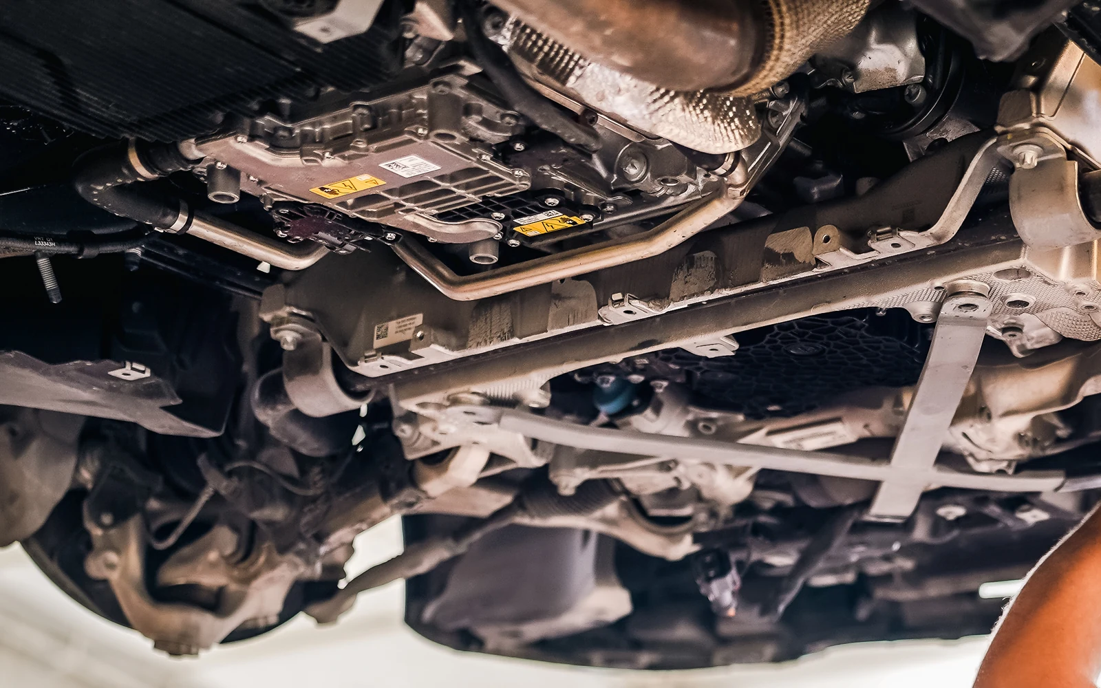 Close view of underbody components beneath a vehicle on a workshop lift.